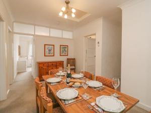 a dining room with a wooden table and chairs at Weymouth Bay Apartment C in Weymouth