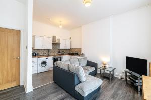 uma sala de estar com um sofá, uma televisão e uma cozinha em One bedroom holiday apartment Colwyn Bay em Colwyn Bay