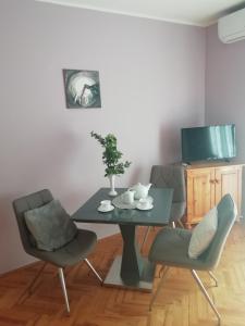 uma sala de jantar com uma mesa e duas cadeiras em Szilvia apartman em Harkány