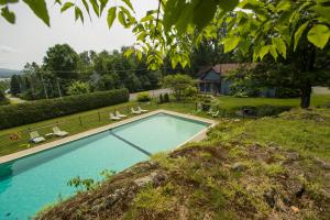 a swimming pool in a yard with chairs and a house at Domaine Jolivent in Lac-Brome