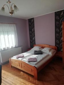 a bedroom with a large bed with a wooden frame at Szilvia apartman in Harkány