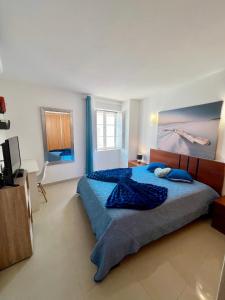 ラゴスにあるCosy Flatsのベッドルーム1室(大型ベッド1台、青い掛け布団付)