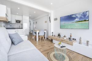 een witte woonkamer met een bank en een tafel bij Albatros Deluxe 15-6 Apartment Levante Beach in Benidorm