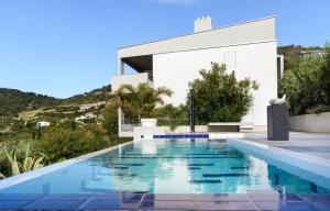 a swimming pool in front of a white house at Art Villa Mara in Vis