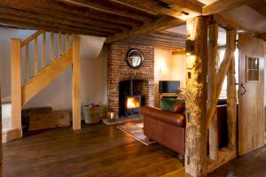 a living room with a couch and a fireplace at Miller Cottage a luxury 1550's cottage in the Historic centre of Saffron Walden in Saffron Walden