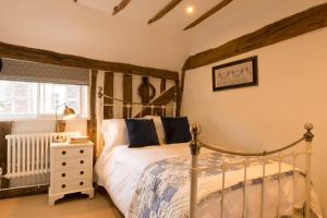 1 dormitorio con cama con dosel y ventana en Miller Cottage a luxury 1550's cottage in the Historic centre of Saffron Walden, en Saffron Walden