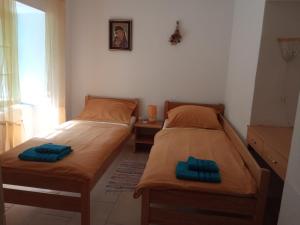 two twin beds in a small room with a table at KATY&MLADEN in Baška