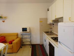 cocina pequeña con sofá, mesa y cocina en la casa dei bebi, en Carrara