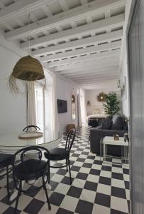 sala de estar con mesa, sillas y sofá en Casa del Sacramento - CASITA CON ENCANTO, en Medina Sidonia