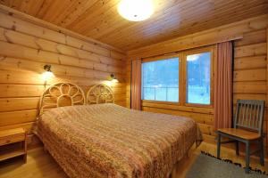 a bedroom with a bed in a log cabin at Villiporo Cabin Levi in Levi
