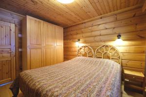 ein Schlafzimmer mit einem Bett in einem Holzzimmer in der Unterkunft Villiporo Cabin Levi in Levi