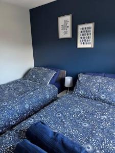 2 letti in una camera da letto con pareti blu di Seaside Apartment - 2 storey 2 bedrooms a Ballycastle