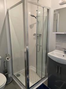 a bathroom with a shower and a toilet and a sink at Seaside Apartment - 2 storey 2 bedrooms in Ballycastle