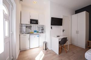 een keuken met witte kasten en een bureau in een kamer bij Chesscom Apartments in Boedapest