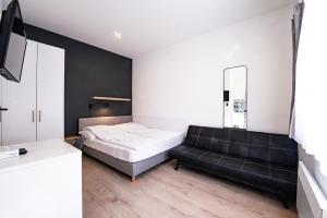 Chesscom Apartments في بودابست: غرفة نوم بسرير واريكة