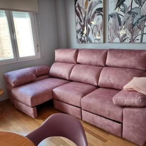 ein Wohnzimmer mit einem rosa Sofa und einem Tisch in der Unterkunft RUA ZAPATERIA 10 PLASENCIA in Plasencia