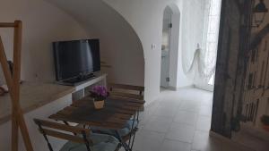 a living room with a small table and a television at Il Vicolo b&b in Putignano