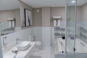 La salle de bains est pourvue de 2 lavabos et d'une douche. dans l'établissement Bisinii Boutique Hotel, à Ciudad del Este