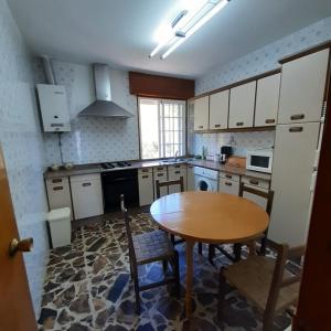 希奧的住宿－CRUCEIRO DE HIO，厨房配有木桌和桌椅