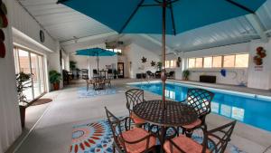 a patio with a table and chairs next to a swimming pool at Stonebrook Lodge Bryson City in Bryson City