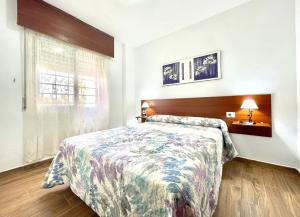 sypialnia z łóżkiem i oknem w obiekcie Apartamento Urb. Palmeras del Sur con piscina w Adeje