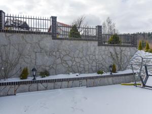 a stone fence with snow on the ground at Willa Na Złotym Widoku in Piechowice