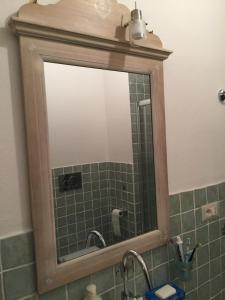 un espejo sobre un lavabo en el baño en Casa Ondina con giardino e Wi-Fi Ussana, en Ussana