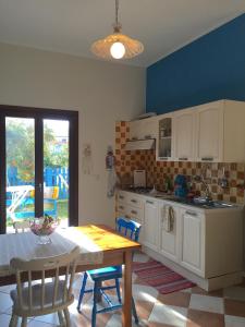 cocina con mesa, mesa y sillas en Casa Ondina con giardino e Wi-Fi Ussana, en Ussana