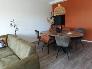 a living room with a table and a couch at Hooivak in Hollum