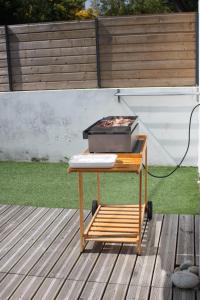a barbecue grill on a picnic table on a deck at Maison chaleureuse toute équipée pour vos vacances in Saint-Quay-Portrieux