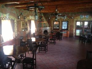a dining room with tables and chairs and a fireplace at Pensiunea la Nise in Sâmbăta de Sus