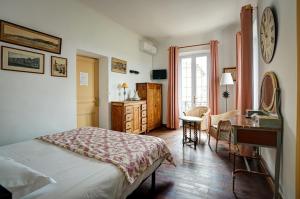 a bedroom with a bed and a table and a desk at La Chaumière, Demeure d'hôtes in Lauris