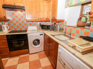 a kitchen with a washing machine and a sink at Forge Cottage in Whitby