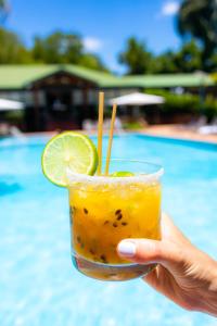 a hand holding a drink with a slice of lime at Iguazu Jungle Lodge in Puerto Iguazú