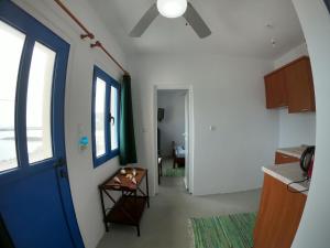 un pasillo con una puerta azul y una mesa en una habitación en AGIAS PELAGIAS LITTLE BEACH HOUSE, en Agia Pelagia - Citera