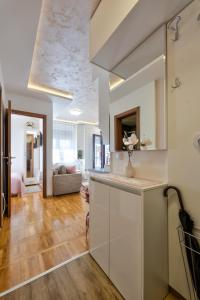 een keuken met witte kasten en een woonkamer bij Apartman Tajena in Zlatibor