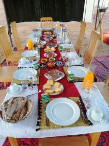 マハミドにあるLuxury Camp desert Maroc Toursの長いテーブルに盛り付けられたお皿