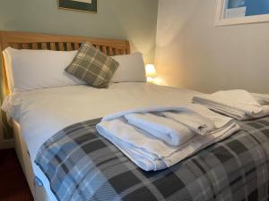 a bed with towels sitting on top of it at The Elks Head Inn in Whitfield