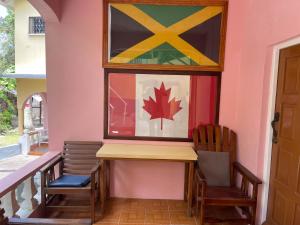 two chairs and a table and a window with a flag at Little Shaw park guest house in Ocho Rios