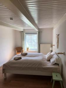 a bedroom with a large bed and a window at Ferienwohnung im idyllischen Gulfhof in Krummhörn