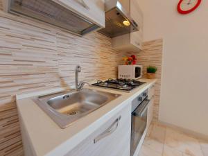 a small kitchen with a sink and a stove at Cortina 1-85 in Lido di Pomposa
