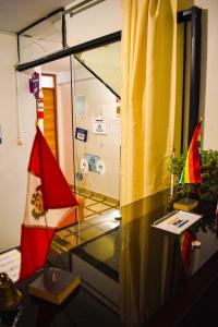 a room with a glass table and a flag at Runas Inn Machupicchu in Machu Picchu