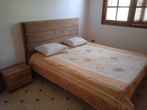 a bed with two pillows on it in a bedroom at Villa luxueuse meublée in Sfax