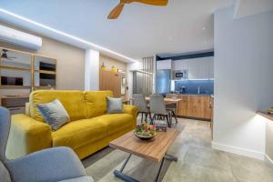 a living room with a yellow couch and a table at NEW Loft Cabel & Parking in Córdoba