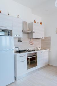 una cocina blanca con armarios blancos y fregadero en DONNA APOLLONIA home holiday, en Monopoli