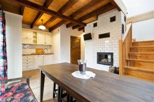 uma cozinha com uma mesa de madeira e uma lareira em Chaty Rysia i Misia - całoroczne domy na wynajem em Wetlina