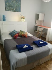 a bedroom with a bed with blue pillows on it at Hyper Centre D'Avignon in Avignon