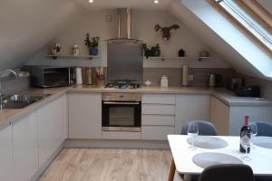 a kitchen with white appliances and a table with chairs at Pinewood Cotage - Country Walks and Relaxation in Blairgowrie