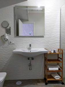 
a bathroom with a sink, toilet and mirror at Hotel El Mirador in Alhaurín el Grande
