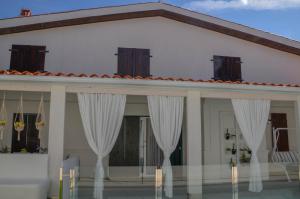 uma casa branca com cortinas brancas em frente em Casa rural Aldea em La Alameda de Cervera
